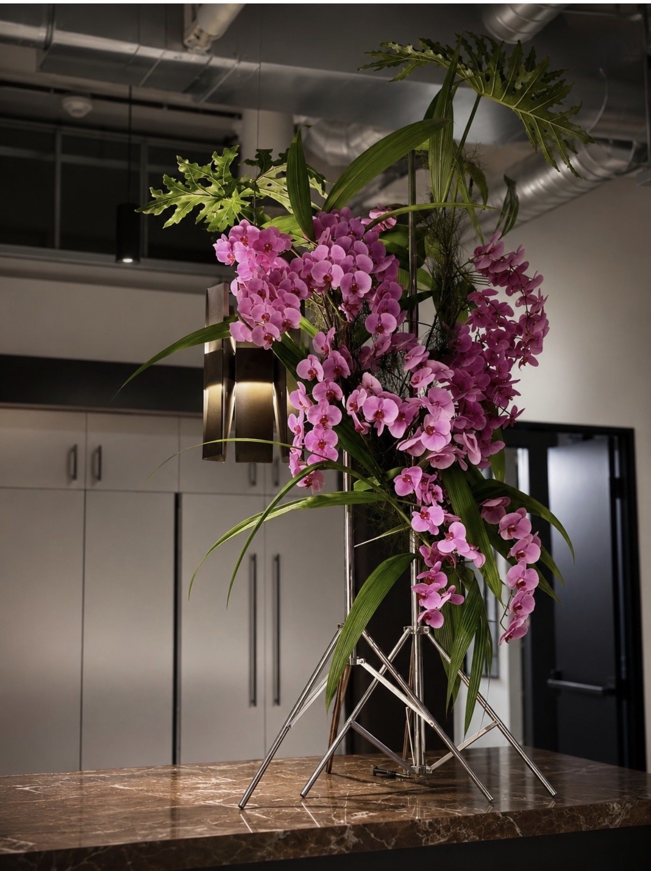 A sculptural orchid installation arranged within an architectural space
